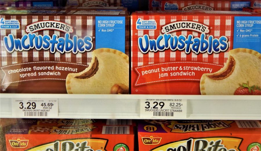 A comparison between two kinds of Smuckers Crustables sandwiches in the frozen foods aisle at Publix highlights their differences. While the PB & J packaging proudly mentions its nutrition facts, the chocolate hazelnut sandwiches does not. (Photo Credit: Ava Rose Weisberg)