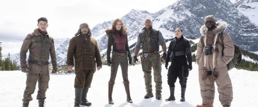 (Lest to Right) Nick Jonas, Jack Black, Karen Gillan, Dwayne Johnson, Awkwafina, and Kevin Hart stand in Jumanjis icy tundra before trying to penetrate Jurgan the Brutals fortress. Unless they can stop him, Jumanji will be a lifeless wasteland forever. (Photo Credit: rogerebert.com)