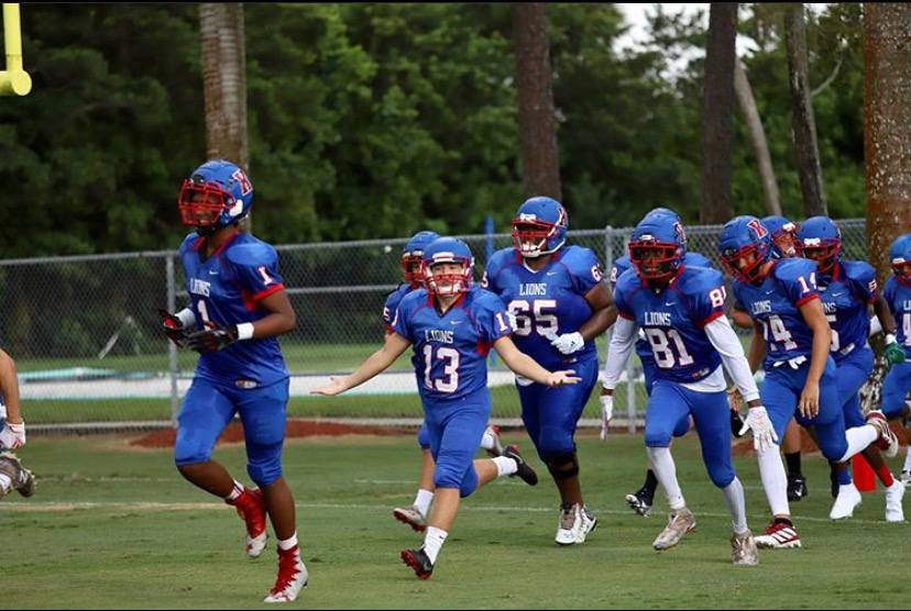 Zakaih Saez, Bernie Cueto, Keschawn Edouard, and Gavin Keen lead The Kings Academys Lions onto the feild ready for a victory in The Kalhert Stadium. (Photo Credit: Laura Rinker)