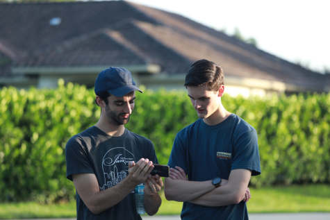 Mr. Parenti and Ryan Cavenaugh are checking something on Parenti's phone.